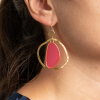 Les boucles d'oreilles Ailes sont parfaites si vous voulez vous faire remarquer. Sophistiquées et élégantes, ces boucles d'oreilles se composent d'un pendentif oval en résine rose et d'un anneau destructuré doré.