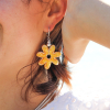 Les boucles d'oreilles Jaune en forme de fleur sont faites à la main dans de la céramique. Elles sont fabriquées et conçues en France sur l'Île d'Oléron.