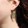 Les boucles d'oreilles Vita sont des boucles d'oreilles en forme d'arbre de vie de couleur kaki Elles sont accompagnées de petites perles vert et doré.