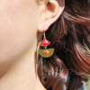 Les boucles d'oreilles Pampelune sont des boucles d'oreilles en forme de demi lune et accompagné de perles orange et rouge en verre et à facette.