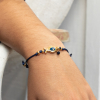 Le bracelet Wanda est un bracelet doré et bleu marine. Il se compose d'une perle en forme de poisson bleu et en métal doré recouvert d'un flash d'or 24 carats et d'un cordon en polyester bleu.