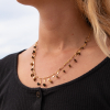 Le collier Joana est un collier multirang composé d'une chaine en métal doré d'un flash d'or 24 carats, d'une chaine composée de pétales en métal doré d'un flash d'or 24 carats et de pierres de couleurs.