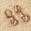 Ces boucles d'oreilles sont composées de perle nacré et d'un coeur en verre rose. Elles mesurent 1.5 cm.