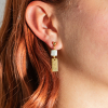 Celaya est une paire de boucles d'oreilles doré et blanc composé de formes géométriques. Elles sont simples et sobres et peuvent donc être offrir sans crainte.