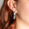 Celaya est une paire de boucles d'oreilles argentée et blanc composé de formes géométriques. Elles sont simples et sobres et peuvent donc être offrir sans crainte : elles plaieront forcément !