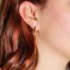 Craquez pour les boucles d'oreilles Eléa, des boucles d'oreilles en métal doré d'un flash d'or 24 carats agrémenté de perles oranges. Une pièce originale et discrète à porter sans modération.