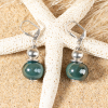 Boucles d'oreilles en céramique vert émeraude et détails argentés.