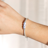 Fogo est un bracelet composé d'un cordon en lin sur lequel est disposé des perles blanches à rayures bleu marine. Un style Retour de plage.