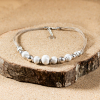 Le collier Linon est un collier fantaisie pour femme. Il est composé de plusieurs fils en lin beige, de perles en céramique blanche et de perles en métal plaqué argent 999.
