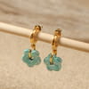 Détail des boucles d'oreilles Marguerite avec anneau doré et perle fleur en céramique turquoise émeraude, création artisanale française élégante