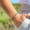 Bracelet Astro Retour de Plage avec étoile de mer dorée, perle de rivière blanche, perle en verre bleu et cordon en nylon bleu marine – bijou artisanal fabriqué en France