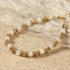 Bracelet Pétronille Retour de Plage en perles carrées de nacre naturelle blanche et perles en métal doré à l'or fin 24 carats, monté sur câble fin avec fermoir mousqueton doré – bijou artisanal fabriqué en France