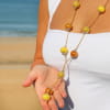 Détail du sautoir Crème avec perles en céramique jaune et médaille Retour de Plage – création artisanale française