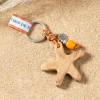 Porte-clefs Patrick, étoile de mer en bois et cordon en cuir orange et perle orange