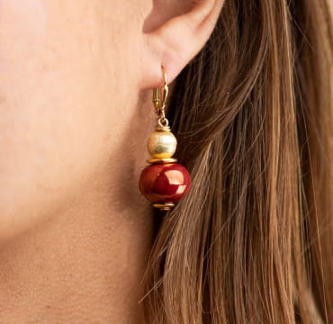 Boucles d'oreilles Amour. Bijou pour femme doré avec une perle en céramique rouge bordeaux.