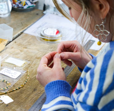 fabrication de bijoux artisanaux en boutique dans l'espace atelier.