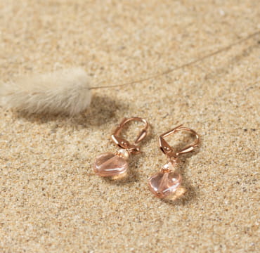 Boucles d'oreilles Jeudi pour enfant, dorées et rose avec un pendentif en verre formant un cœur.