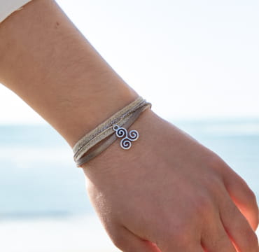 Bracelet Kemper pour femme. Fabriqué en lin avec un pendentif en forme de triskel.