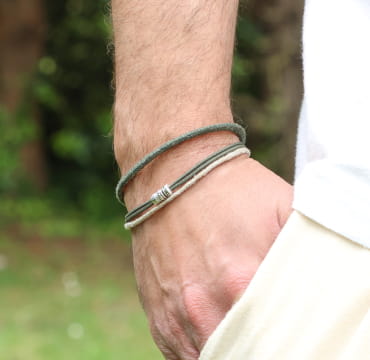 Bracelet homme sur très belle main d'homme Aride en métal plaqué argent avec tressage kaki et perles multicolores, fabrication artisanale française.