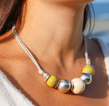 collier Ancolie argenté avec perles jaunes et multicolores porté sur peau bronzée