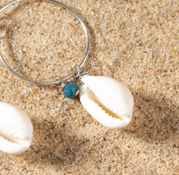 Détail sur les boucles Amélie, reflets bleutés et monture argentée artisanale.