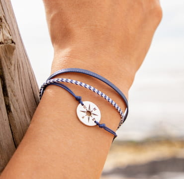 Bracelet Vent : une médaille de rose des vents agrémentée de 3 cordons bleu marine.