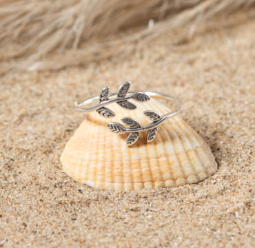 bague Sakura posée sur un coquillage, détail argent et perle centrale