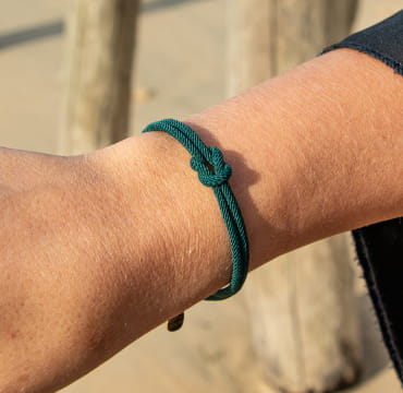 Bracelet couple : un bracelet composé de 2 cordons en polyester vert sapin qui sont noués par un noeud plat.
