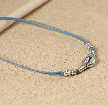 Collier Seignosse – bijou en métal plaqué argent avec pendentif cauri, perles argentées et cordon bleu montana en coton, fabrication artisanale française