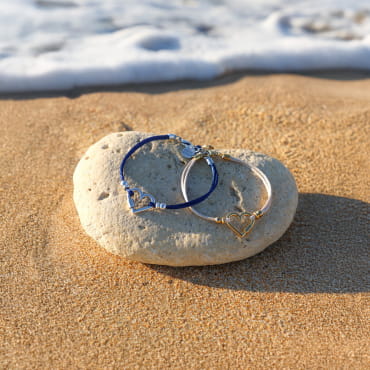 Bracelet doré aux tons naturels posé sur le sable – fabrication française