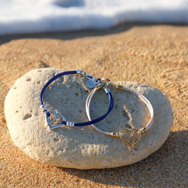 Bracelet bleu marine en perles argentées, posé sur le sable – fabrication artisanale française