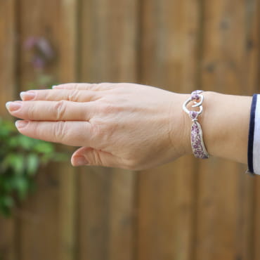 Bracelet Fimo porté au poignet, perles violettes et détails argentés – fait main en France