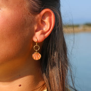 boucles d’oreilles Caliopee dorées ornées de perles corail portées