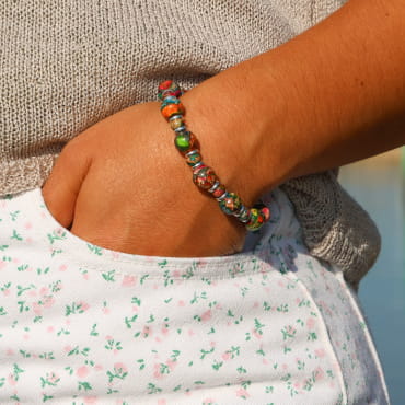 bracelet Jungle argenté orné de perles multicolores porté au poignet