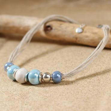 Collier en céramique, en lin et en métal argenté. Créé en France.