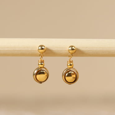 Boucles d’oreilles Astrod en métal doré avec pendentif artisanal, création française.