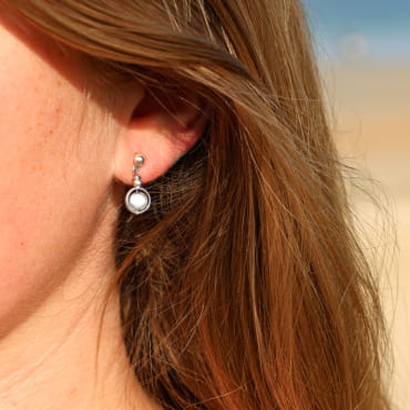 Boucles d’oreilles Astrod en métal doré avec pendentif artisanal, création française.