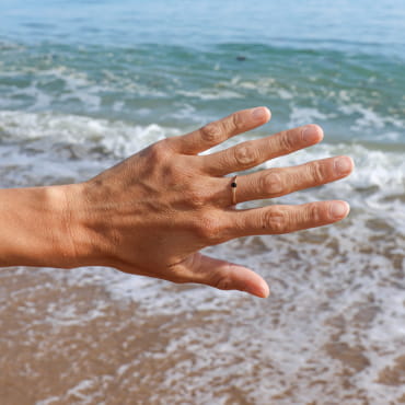bague Vannetaise dorée avec perle noire, portée en bord de mer, création artisanale française