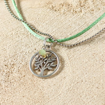 collier Vie argenté avec pendentif arbre de vie et perle verte présenté à plat