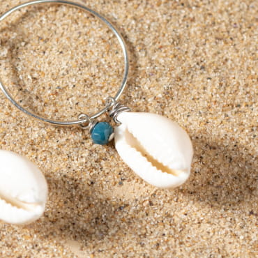 Détail sur les boucles Amélie, reflets bleutés et monture argentée artisanale.