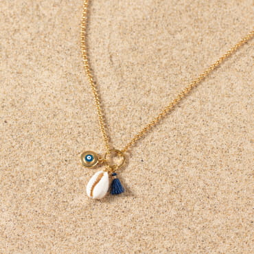 Collier Grèce doré avec coquillage et perle bleu marine, ambiance estivale.