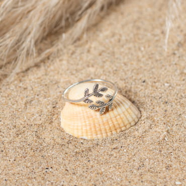 bague Sakura sur fond sable, monture argentée fine avec motif floral
