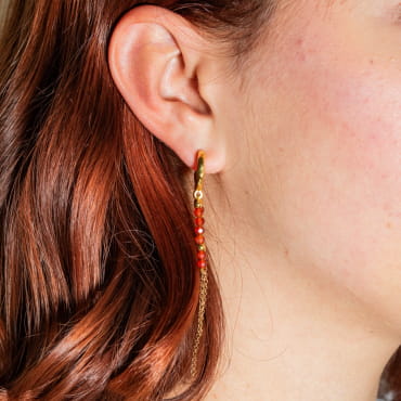 Craquez pour les boucles d'oreilles Eléa, des boucles d'oreilles en métal doré d'un flash d'or 24 carats agrémenté de perles oranges. Une pièce originale et discrète à porter sans modération.