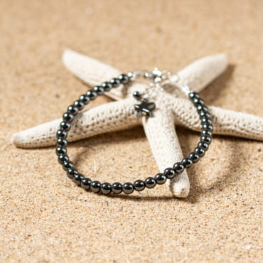 bracelet Goudron gris composé de perles facettées et d’une perle centrale argentée