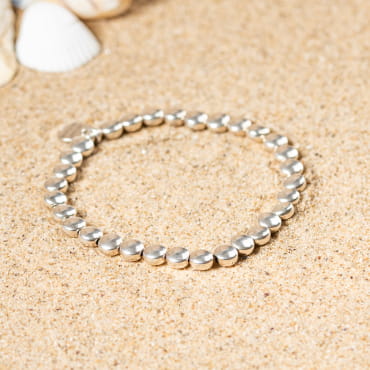 Bracelet Nasa en métal argenté, perles texturées sur fil souple, élégance minimaliste.