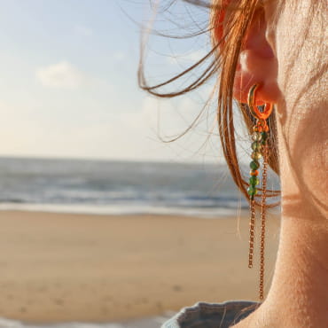 Boucles Elea dorées aux perles vertes et forme géométrique, portées en extérieur – fabrication française
