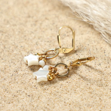 Détail des boucles d'oreilles Vega avec pendentifs en étoile et perles en nacre blanche, fermoir dormeuse doré – création artisanale française
