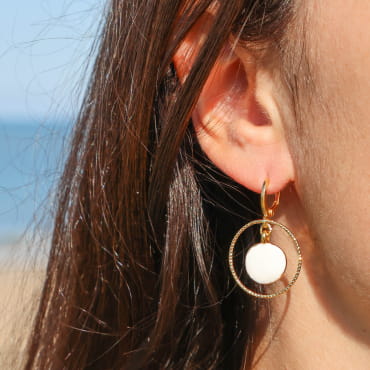 Boucles d'oreilles Zagora Retour de Plage en métal doré 24 carats, cercle suspendu encadrant un pendentif rond en émail blanc brillant – bijou artisanal fabriqué en France