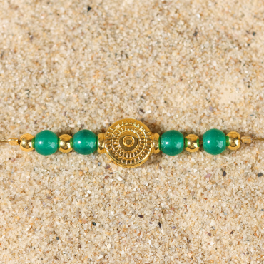Gros plan du bracelet Tavira sur fond sable – alliance doré et vert profond