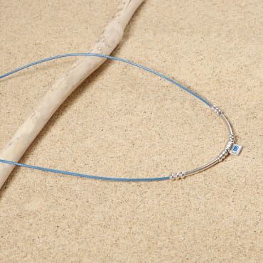 collier Dakota argenté avec perle bleu Montana sur sable clair